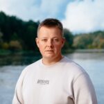 A serene portrait of a man standing by the Neman River in Grodno, Belarus.