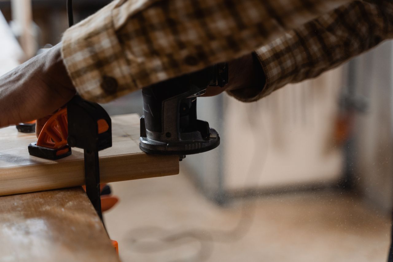 Crafting Captivating Headlines: Your awesome post title goes here A carpenter works with an electric router on wood indoors, showcasing craftsmanship.