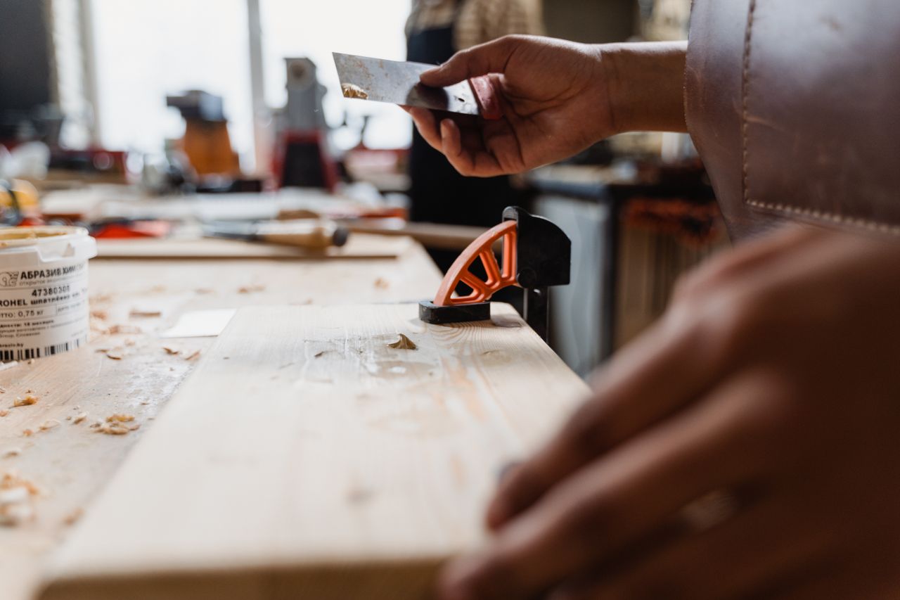faq-img Close-up of a craftsman's hands at work in a woodworking studio. Precision and skill on display.